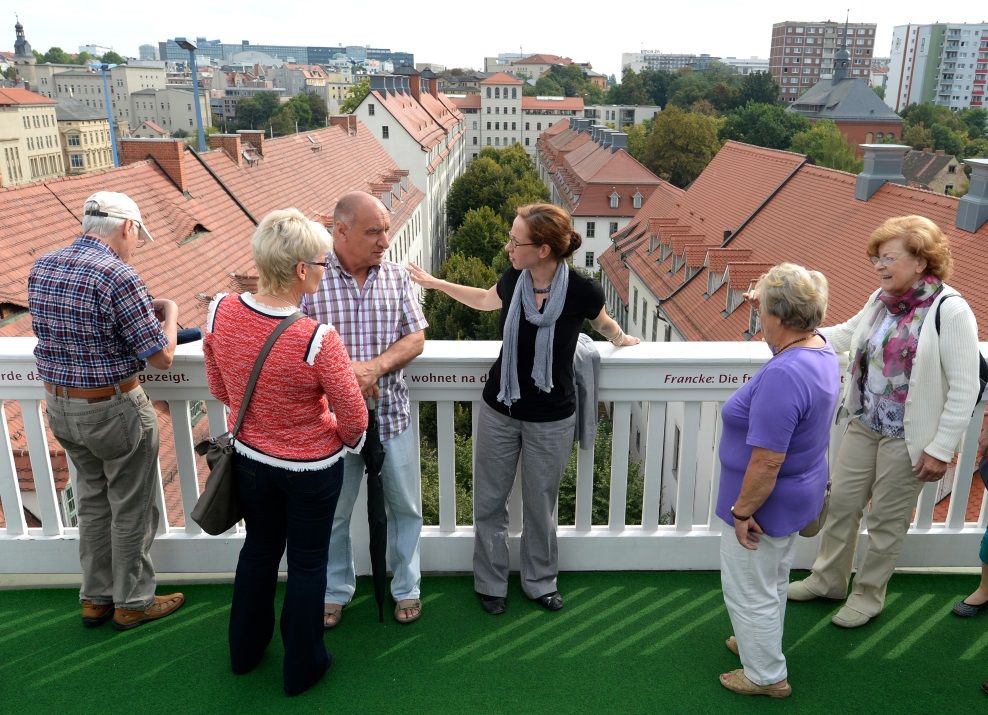 Eine Führerin erklärt einer Besuchergruppe vom Altan des Historischen Lindenhofs aus die zahlreichen Häuser der Schulstadt der Franckeschen Stiftungen in Halle (Saale).
