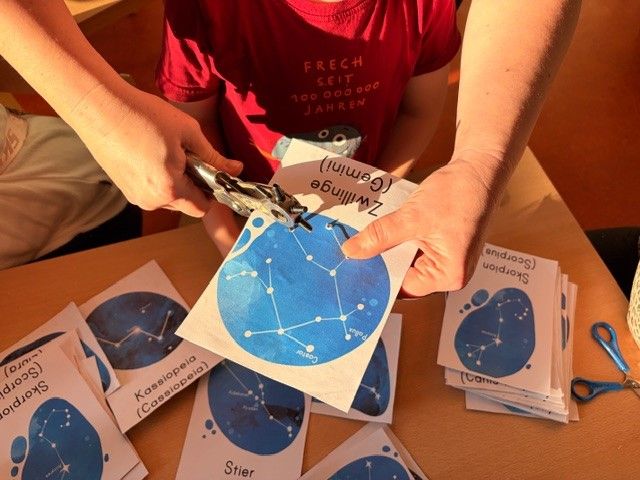 Mama und Kind bohren Löcher in Sternenkarte