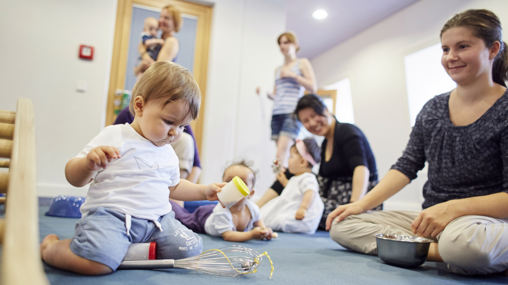 Foto: Junge Mütter spielen mit ihren Säuglingen in der Familienspielgruppe