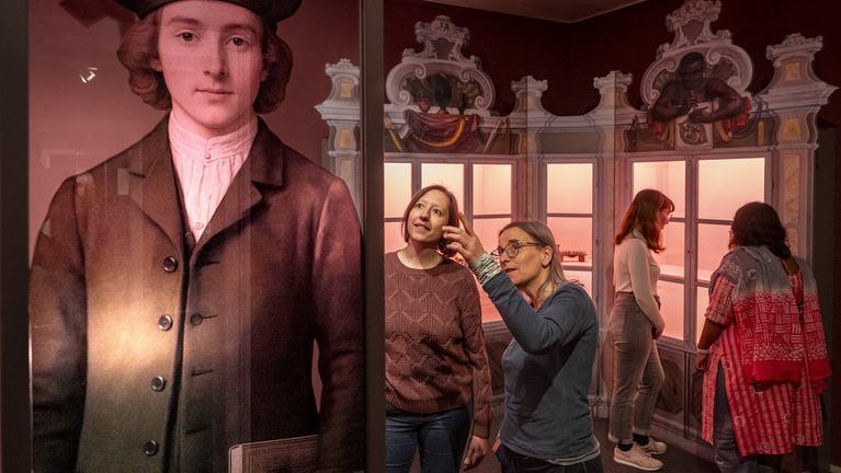 Vier Frauen betrachten verschiedene Objekte in der Ausstellung