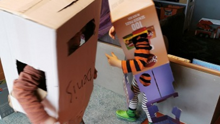 2 Kinder haben einen Karton auf den Kopf
