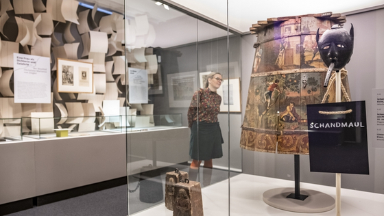 Blick in den Ausstellungsraum "Marktplatz" mit einer historischen Bestrafungsinstrumenten: einer Schandmaske und einem Schandmantel.