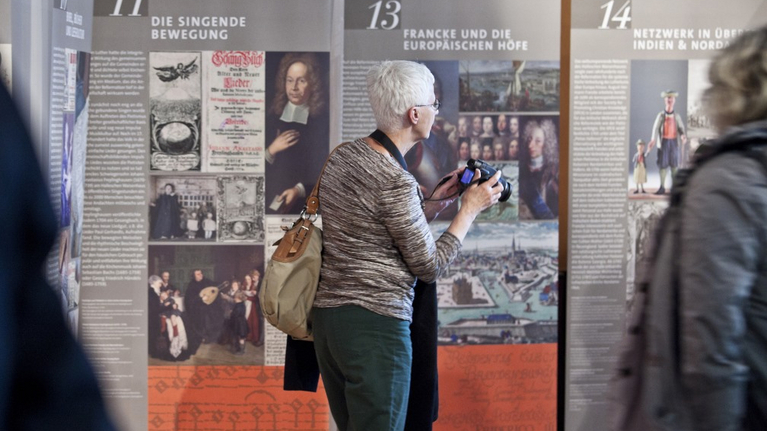 Eine Frau besichtigt die Wanderausstellung Hallescher Pietismus und Reformation in der Vertretung des Landes Sachsen-Anhalt in Berlin