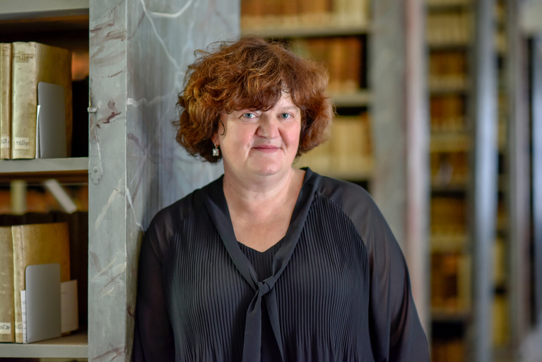 Die neue Direktorin der Franckeschen Stiftungen lehnt an einem Bücherregal in der Historischen Kulissenbibliothek