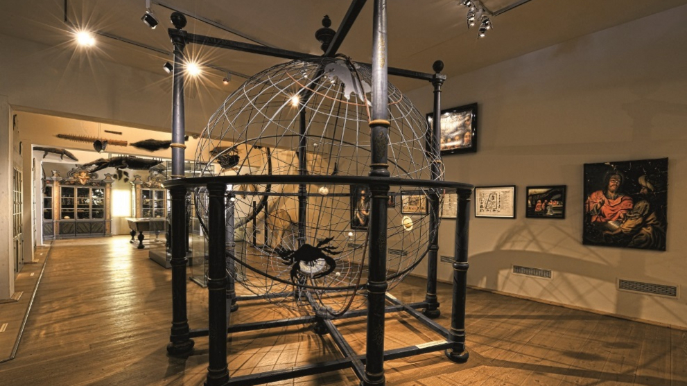 Blick in die Kunst- und Naturalienkammer mit dem raumgroßen Modell des Universums im Vordergrund.