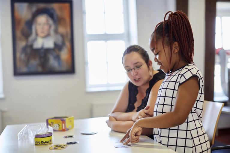Eine Schülerin verbessert spielerisch ihre Sprachkompetenz. Eine Freiwillige des Familienzentrums hilft ihr dabei.