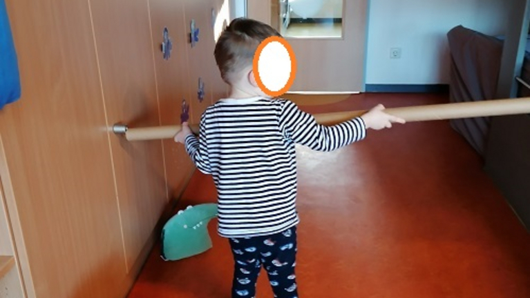 Kind hält eine große Papprolle