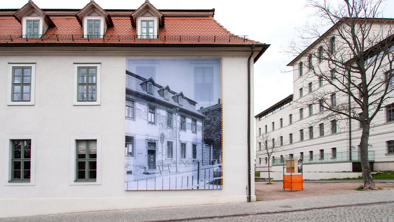 A huge banner on the Economy building shows the ruined state of the building around 1990.
