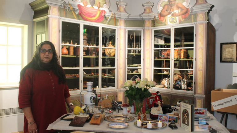 In front of the India cabinet in the Wunderkammer, Asma Menon presents the objects she has selected for the Germany cabinet in Tharangambadi.