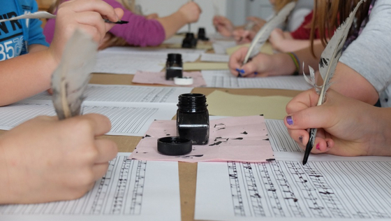 Kinder schreiben mit Feder und Tinte