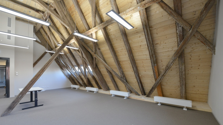 Blick in das ausgebaute Dachgeschoss der Großen Scheune, in der die Dachkonstruktion bei der Sanierung sichtbar geblieben ist.