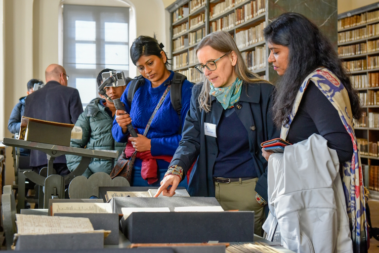 Wissenschaftlerinnen und Wissenschaftler aus Inien lesen in den in der Historischen Bibliothek ausgelegten Tamil-Drucken. .